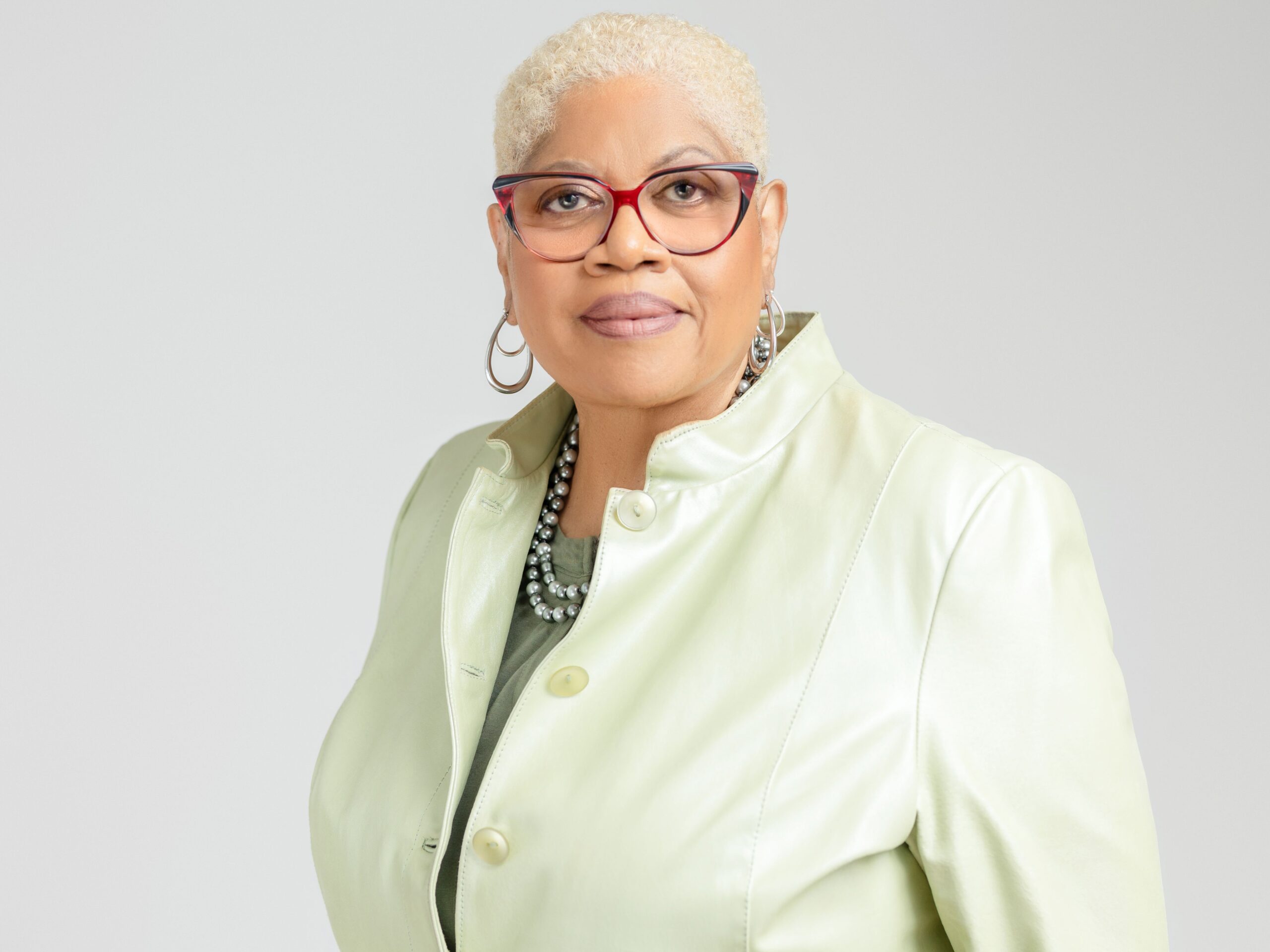 woman in glasses and green jacket for headshot photoshoot