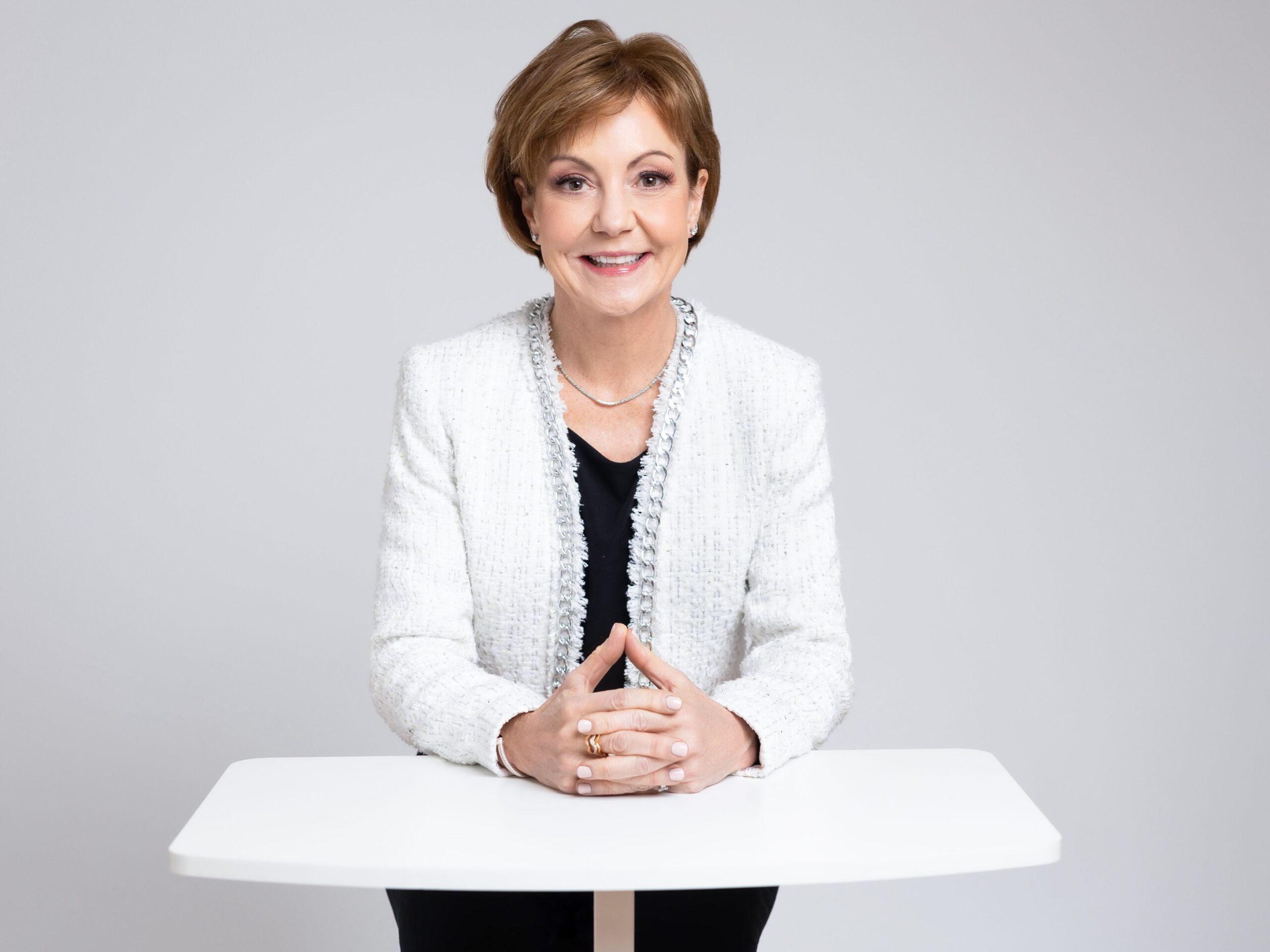 headshots of woman in white jacket with hands folded