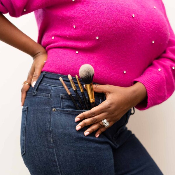 lifestyle branding image of woman holding makeup brushes in pocket