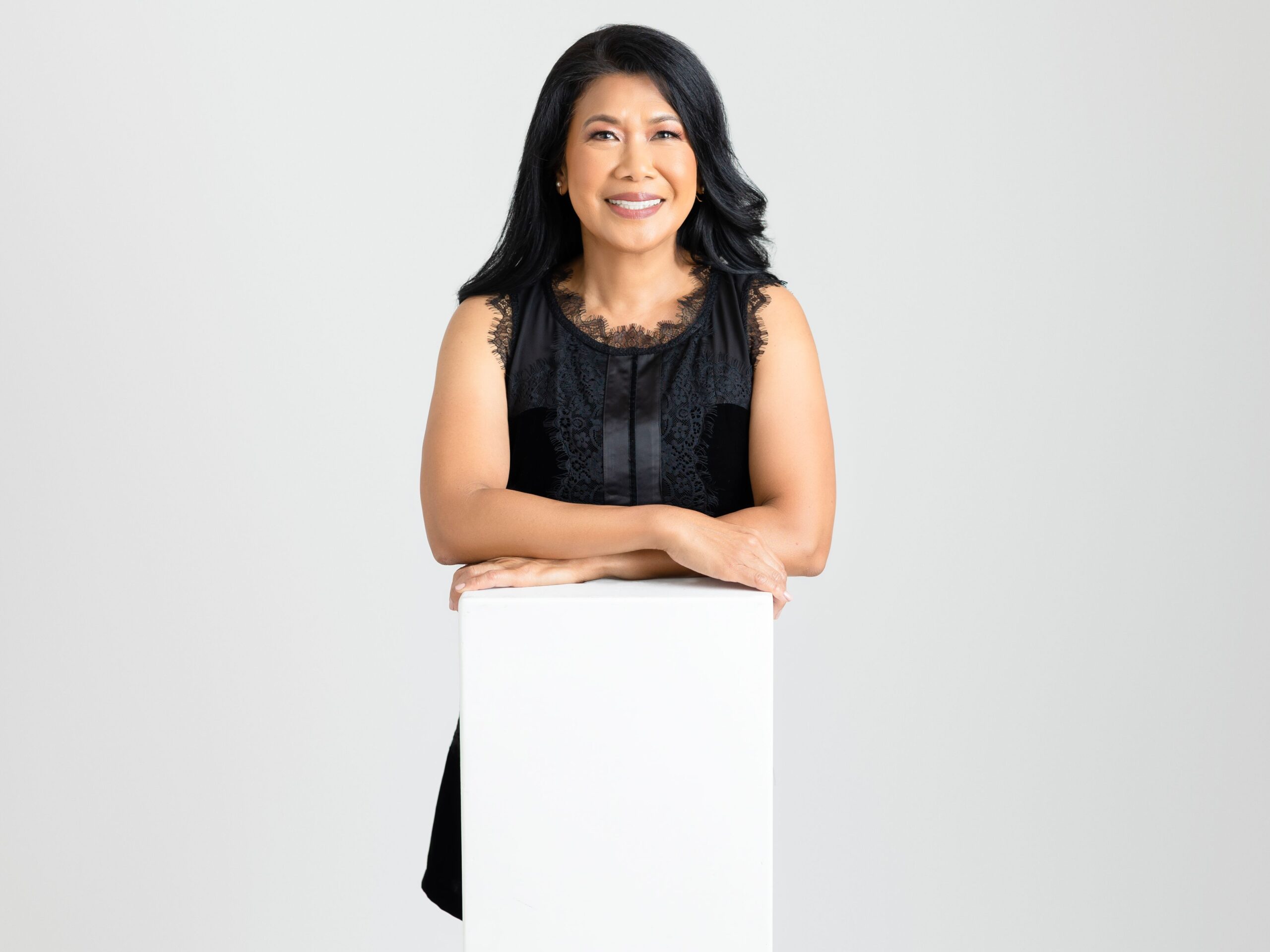 woman in black poising at stool for headshot photos