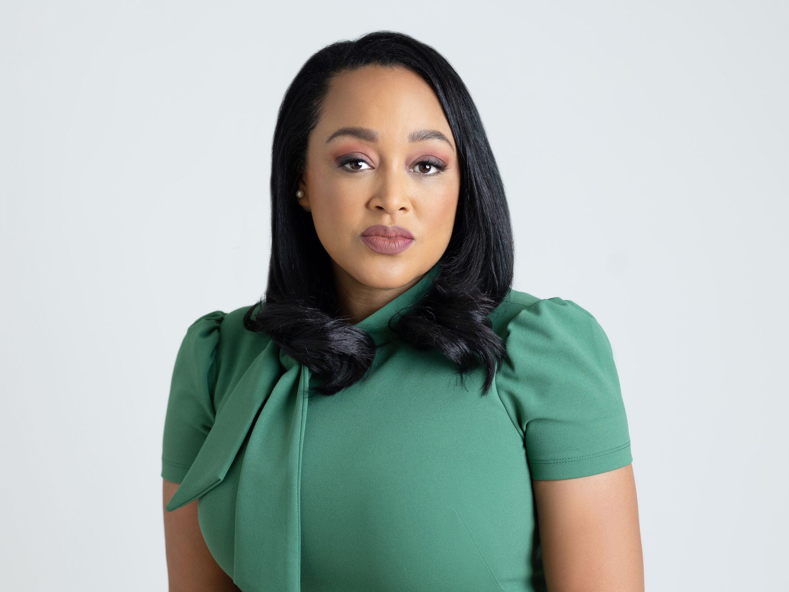 woman in green dress posing for headshots at market street studio
